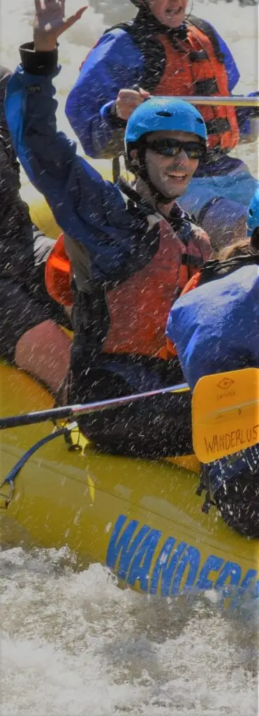 Professor Medhi Majbouri in boat, wearing protective gear while white water rafting