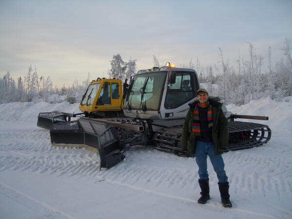 Babson Professor Michael Goldstein, Ph.D., in front of snow clearing machines on the JV Ice Road to the diamond mines.